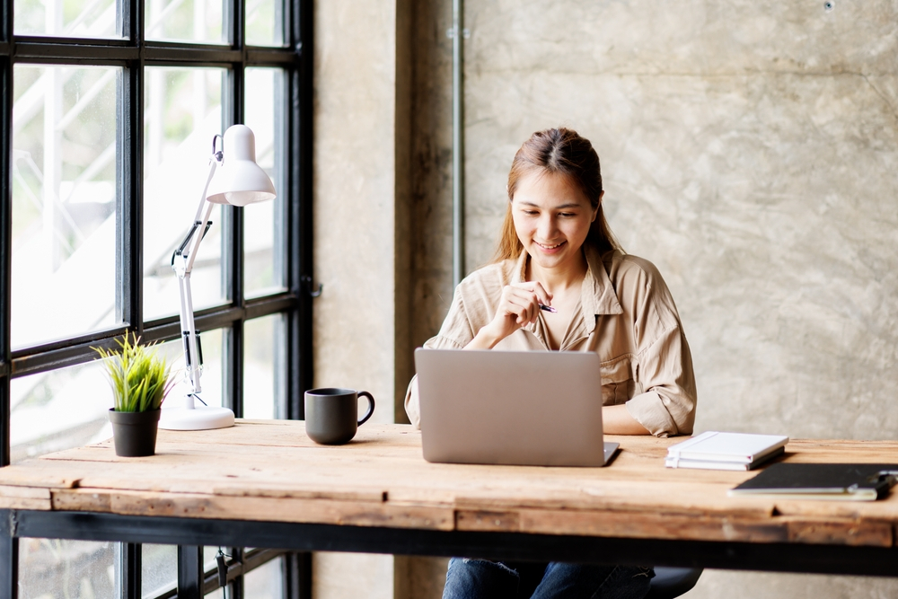 Top 15 Remote Jobs You Can Do From Anywhere in 2024: Picture of a young lady working remotely on a laptop from her home office.